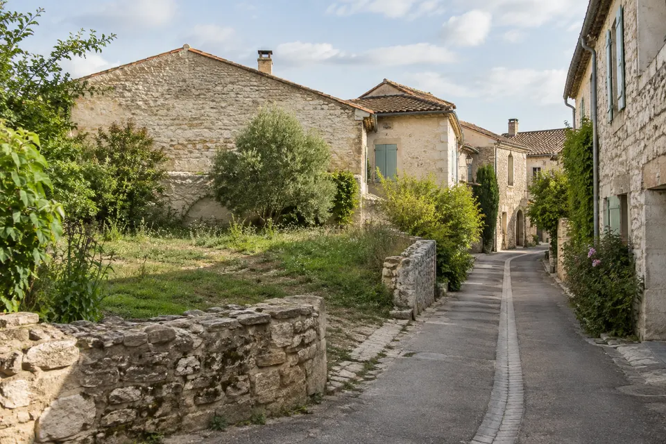 Parcelle libre le long d’une rue bordée de maisons de pierre